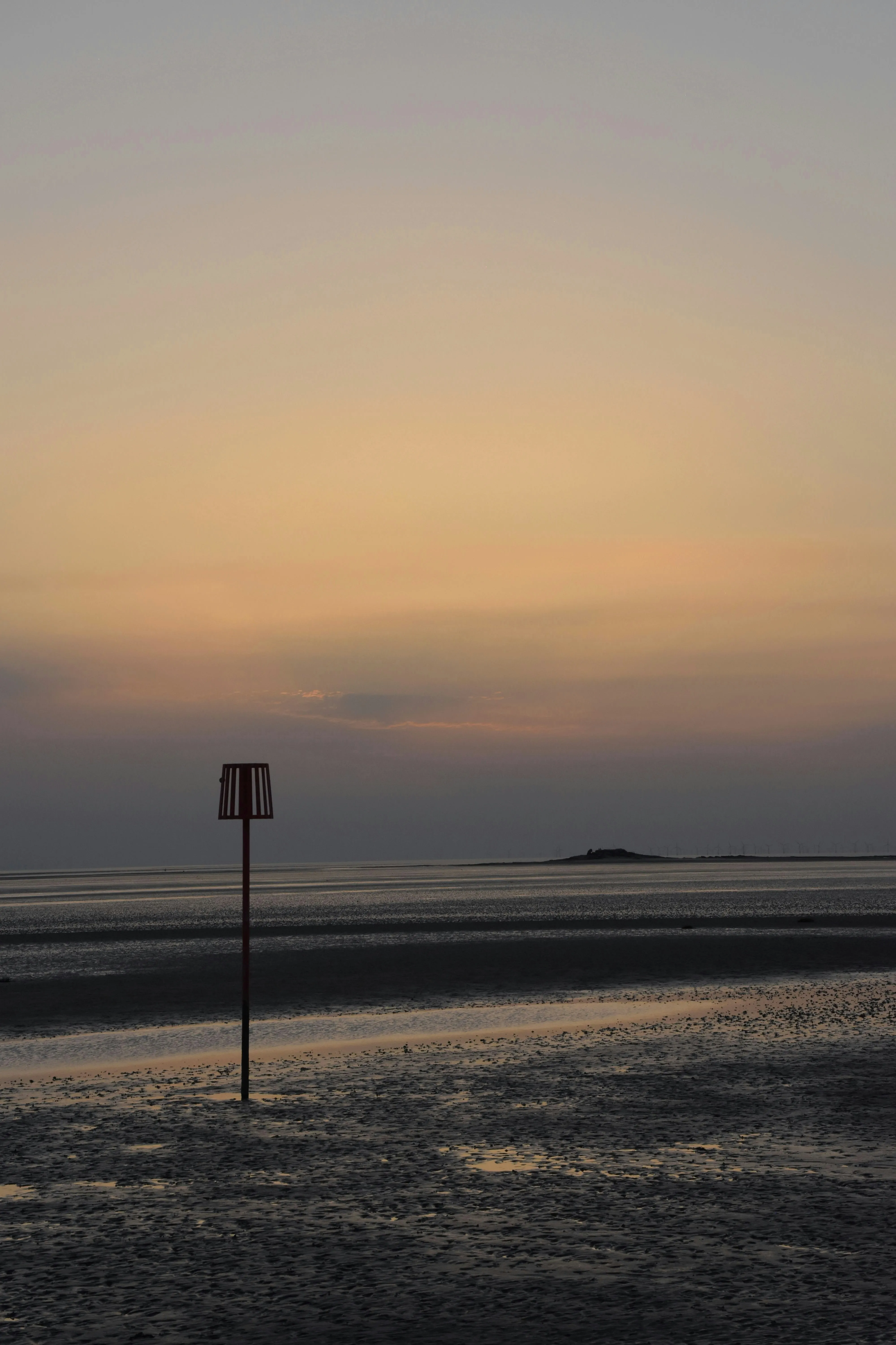 Warm sunset over the Dee estuary sands and a tidal marker near Hilbre